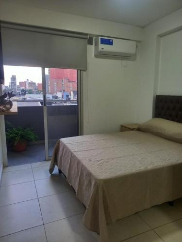 een slaapkamer met een bed en een groot raam bij Lavalle 665 in San Miguel de Tucumán