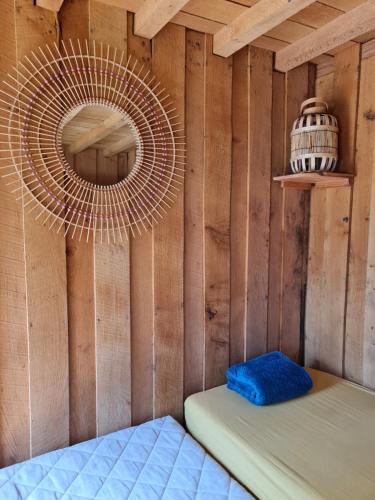 une chambre avec un lit dans un mur en bois dans l'établissement Cabane du Beau-Regard, à Saint-Didier-sur-Arroux