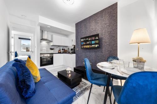 a living room with a blue couch and a table at Modern One Bedroom Flat - Sleeps 3 - Transport Links - Finchley Road, Euston, King Cross Station - London NW3 in London