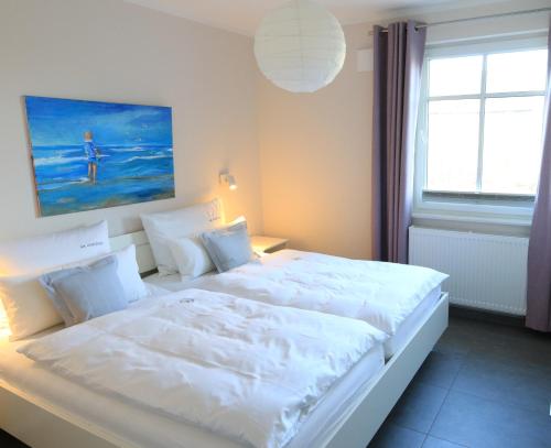 a bedroom with a large white bed with a window at Am Horizont No 3 Fewo für 4 Pers, 2 Schlafzimmer, W-LAN, Homeoffice geeignet, Garten, Strandkorb, BBQ- Grill, Parkplatz in Zingst
