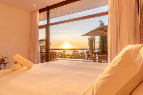 甘博阿的住宿－VILAS de LUXO，一间卧室设有一张床,享有海景