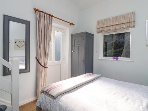 a bedroom with a bed and a window and a mirror at Foxholes Lodge in Settle