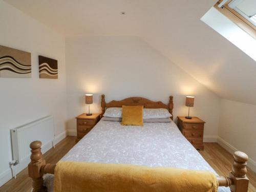 um quarto com uma cama com duas mesas de cabeceira e dois candeeiros em Rock Lawn Cottage em Glanbannoo Upper