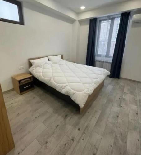 1 dormitorio con 1 cama grande y suelo de madera en Lily house, en Ereván