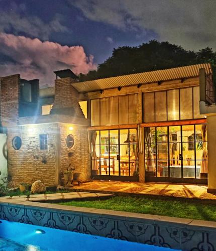 une maison avec une piscine en face de celle-ci la nuit dans l'établissement Departamento los lapachos, à Villa Allende