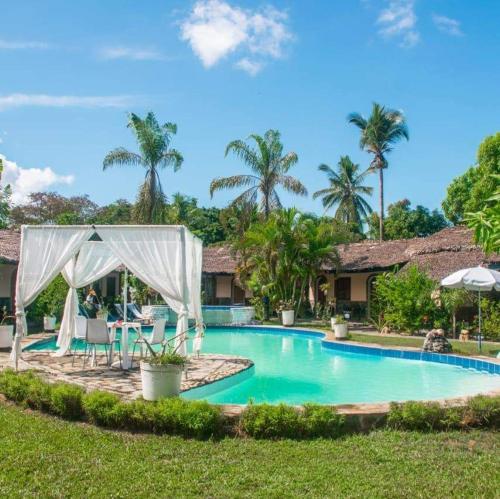 a swimming pool in front of a villa at Madiro hôtel in Nosy Be