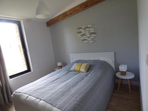 een kleine slaapkamer met een bed en een raam bij Ty Maez - Calme et confort à Sarzeau- Les Gites de Rhuys in Sarzeau