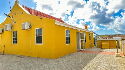 un edificio amarillo con techo rojo en Villa Rubia Bonaire en Kralendijk