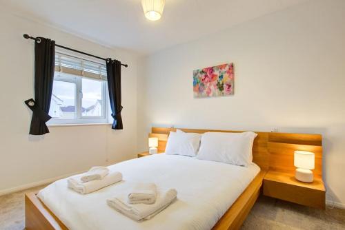Comfortable 3 bed house in Chelmsford في تشيلمسفورد: غرفة نوم عليها سرير وفوط