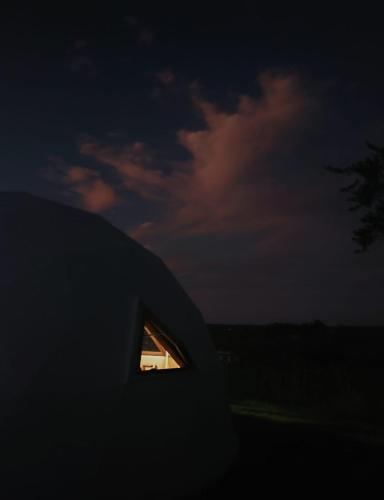 塔夸倫博的住宿－Domo guidaí，夜间建筑物一侧的小窗户