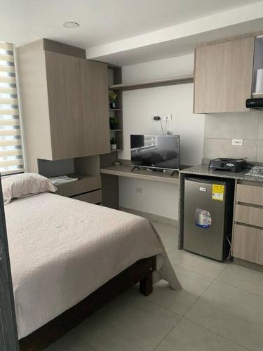 ein Schlafzimmer mit einem Bett und eine Küche mit einem Herd in der Unterkunft Nuevo y bonito Apartamento in Popayan
