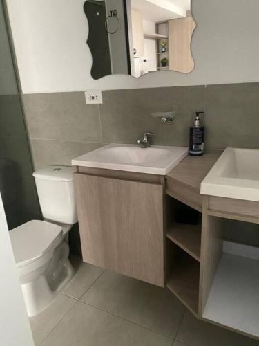 een badkamer met een wastafel, een toilet en een spiegel bij Nuevo y bonito Apartamento in Popayan
