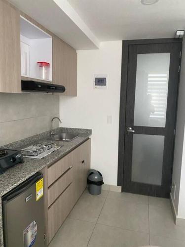 uma cozinha com uma porta, um lavatório e um fogão em Nuevo y bonito Apartamento em Popayán