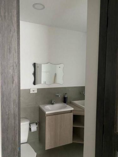 een badkamer met een wastafel, een toilet en een spiegel bij Nuevo y bonito Apartamento in Popayan