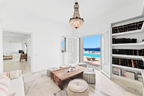 a living room with a table and a view of the ocean at MichaelAngelo Villa in Mýkonos City
