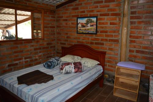 1 dormitorio con 1 cama en una pared de ladrillo en Casa de campo independiente sector Chachimbiro –Urcuqui, en Ibarra