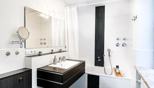 a white bathroom with a sink and a mirror at NEU - Zentrum, 3 Zi, free Tiefgarage, smart TV, WLAN in Augsburg