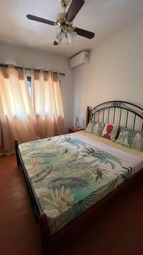 a bed in a bedroom with a ceiling fan at Résidence NATANGUE 1 - Studio La Bella in Sali Nianiaral