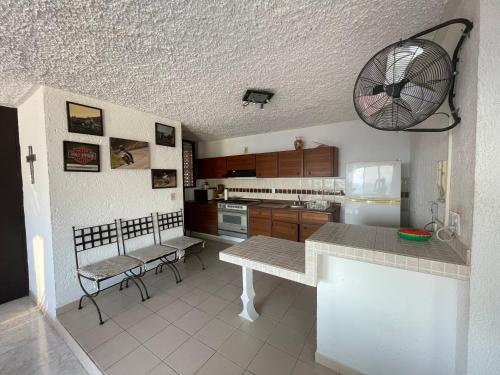a kitchen with a table and chairs in a room at Costera, depa hasta 9 personas con vista al mar, alberca, terraza y aire acondicionado in Acapulco