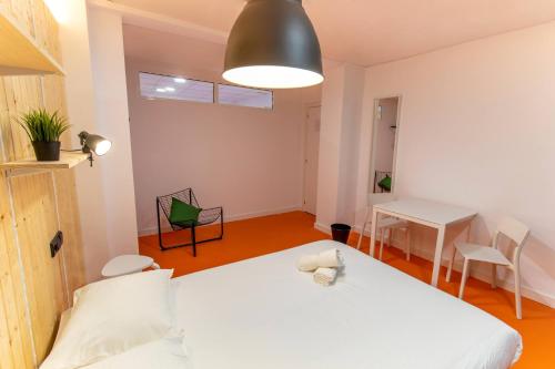 1 dormitorio con cama blanca y mesa en Koala Hostel Mercado, en Alicante