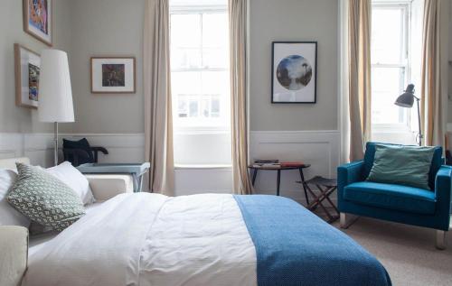 a bedroom with a bed and a blue chair at Traditional Studio Apartment in Fitzrovia near Oxford Street in London