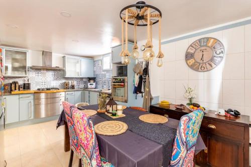 une cuisine avec une table et une horloge au mur dans l'établissement Cosy home, à Nogent-sur-Marne