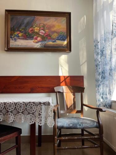 a table and a chair and a painting on a wall at APARTAMENT SPALSKIE KLIMATY in Spała