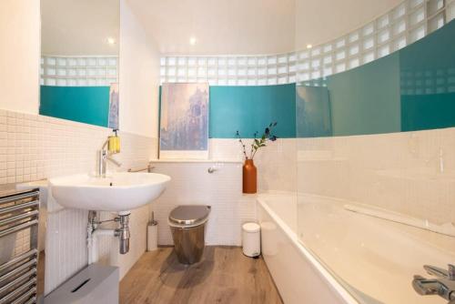 a bathroom with a sink and a bath tub at Central Soho Warehouse Loft with Concierge in London