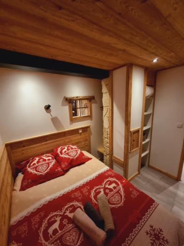 - une chambre avec un lit doté d'oreillers rouges et d'une échelle dans l'établissement Appartement chalet montagne cosy 8 places, à Réallon