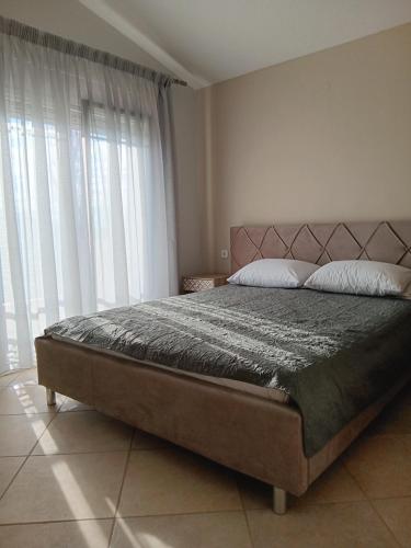 a bedroom with a large bed and a large window at Babis House in Limenaria
