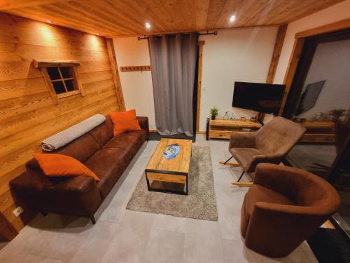 un salon avec un canapé, des chaises et une télévision dans l'établissement Appartement chalet montagne cosy 8 places, à Réallon