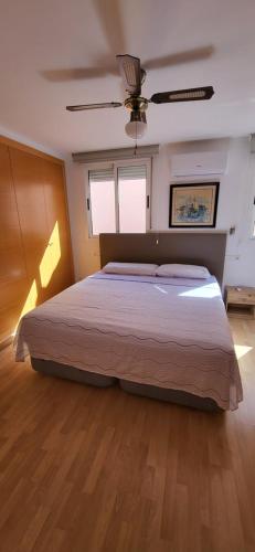 a bedroom with a large bed and a ceiling fan at APARTAMENTO VISTASALRIO ADRIANA,Montanejos in Montanejos