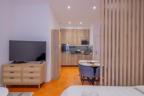 une chambre avec une table et une télévision dans l'établissement Appartement de Charme, à Aix-en-Provence