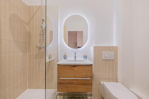 uma casa de banho com um lavatório e um chuveiro com um espelho. em Appartement de Charme em Aix-en-Provence