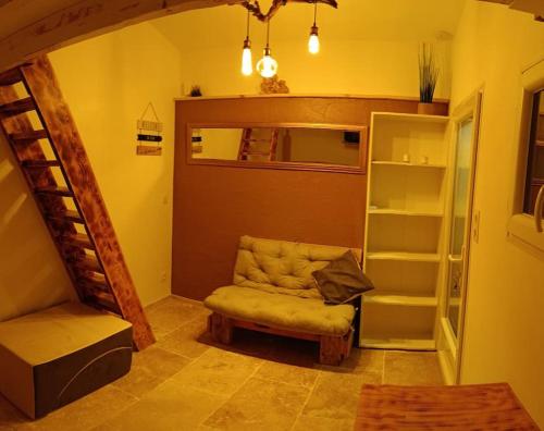 une chambre avec un canapé, une chaise et un escalier dans l'établissement Studio mezzanine, jardin et jacuzzi, à Lorgues