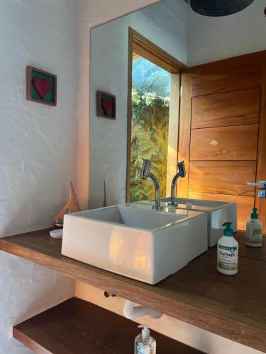 baño con un gran fregadero blanco en una encimera de madera en CasaMí en Ilhabela