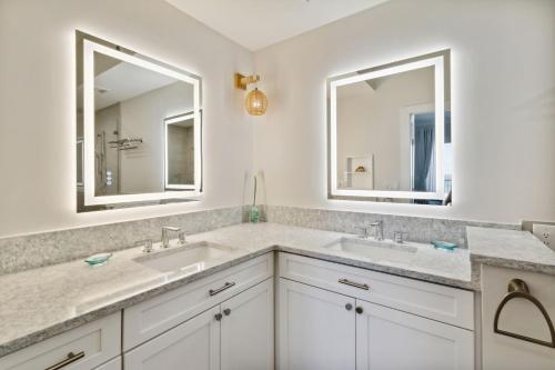 a bathroom with two sinks and two mirrors at 58 Ocean Place - Luxury 2BR 2Ba oceanfront condo right next door to the Ritz Carlton in Fernandina Beach