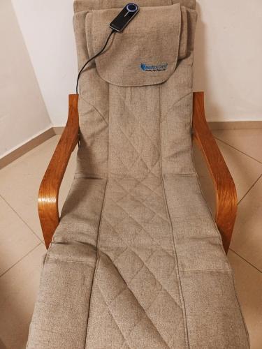 a remote control sitting on the back of a chair at Beach Suite Israel - Indoor Pool, Best View, Gym, Massage Chair, Spa ביץ סוייט ישראל - נוף ים מאלף, בריכה מקורה, כיסא מסאז, חדר כושר וספא in Ashqelon
