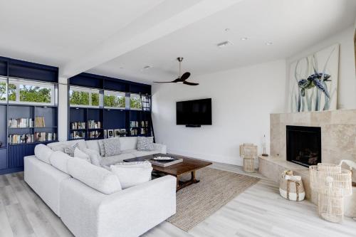 a living room with a white couch and a fireplace at The Narrows- Stunning Bayfront Villa on Captiva in Captiva