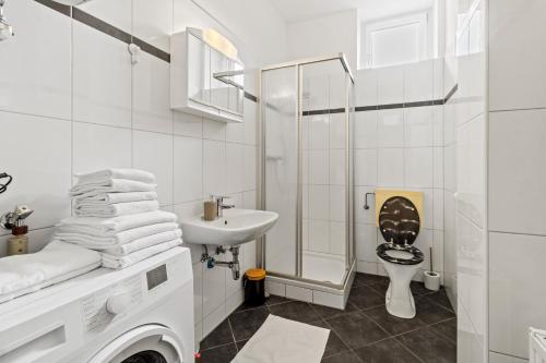 a white bathroom with a toilet and a sink at Dein Zuhause fern von Zuhause in Donawitz