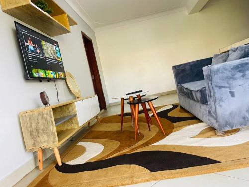 a living room with a table and a couch at Serenity in style in Kampala