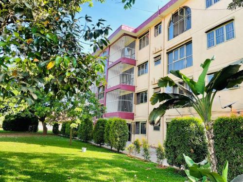 an apartment building with a lawn in front of it at Serenity in style in Kampala