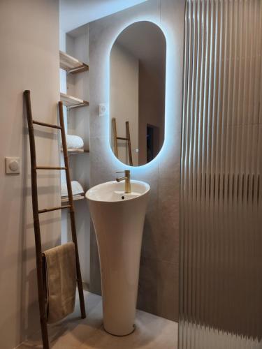 une salle de bain avec un lavabo et un miroir dans l'établissement Cottage du Fort 50 mètres de la plage, à Le Portel
