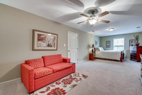 a living room with a red couch and a bed at Pool Table and Patio Cozy Lawrenceville Apt in Lawrenceville