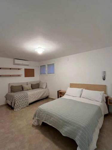 a bedroom with two beds and a couch in it at Casa Galiana. in Argés