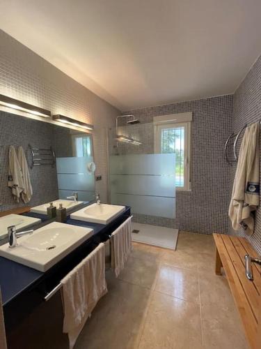 a bathroom with two sinks and a large mirror at Casa Galiana. in Argés