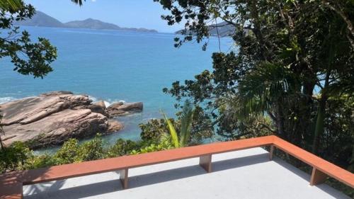 a view of the ocean with a bench overlooking it at BH58: Refúgio Romântico com Vista pro Mar in Ubatuba