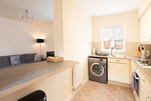 uma cozinha com máquina de lavar e secar roupa num quarto em OPP Exeter - Lovely 2 bed offering BIG SAVINGS booking 7 days or more! em Exeter