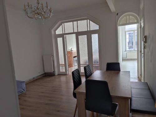 uma sala de jantar com uma mesa e cadeiras e um lustre em Room in Guest room - Chambre Dhote A Bruxelles W em Bruxelas