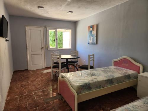 Zimmer mit 2 Betten, einem Tisch und einem Fenster in der Unterkunft DEPARTAMENTO CENTRO in Zapala